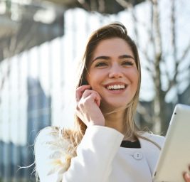 woman in white blazer holding tablet computer