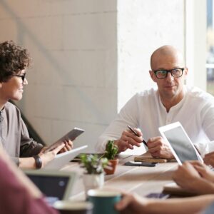 photo of man sitting in front of people
