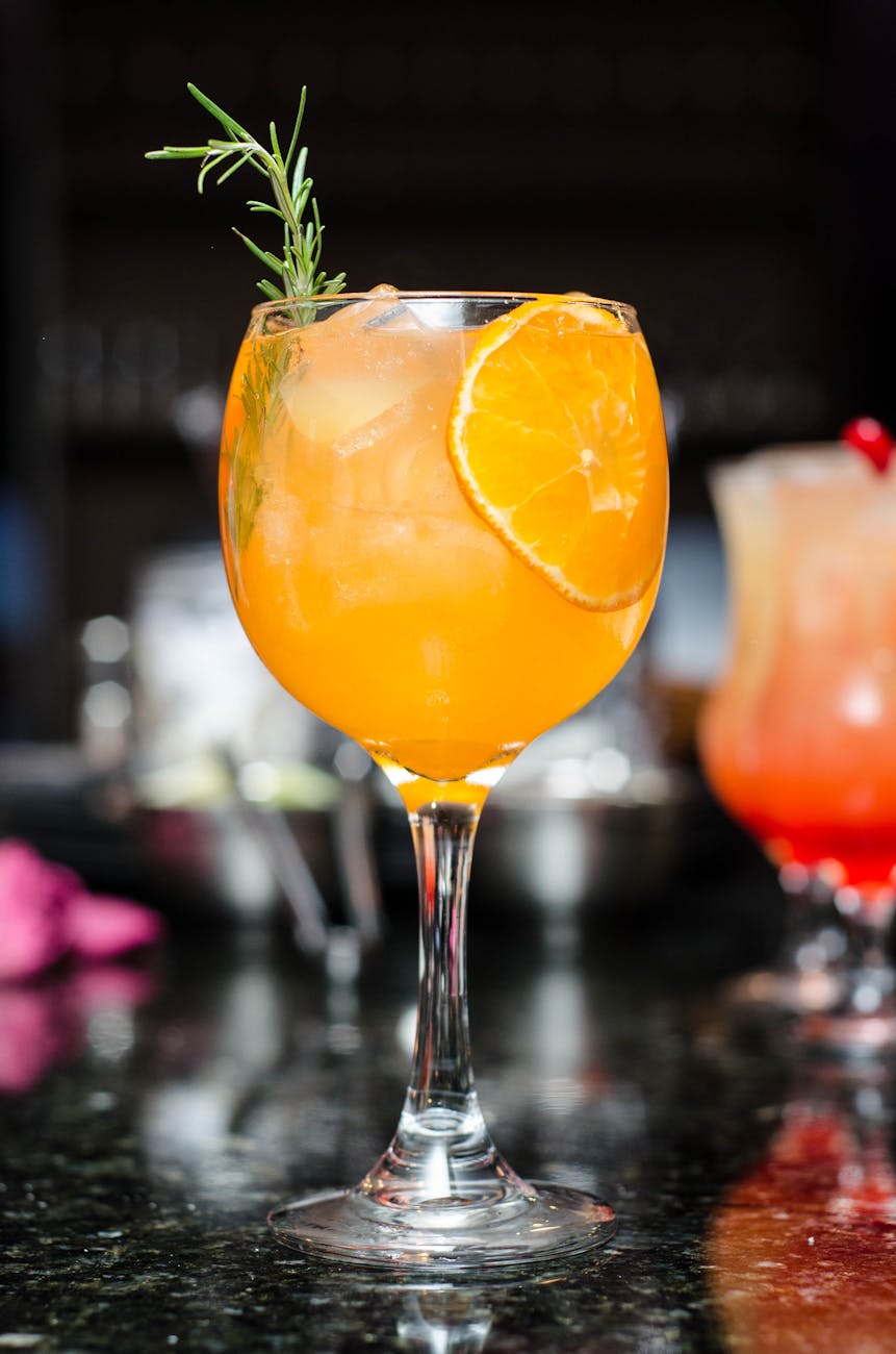 clear glass footed drinking glass with orange juice