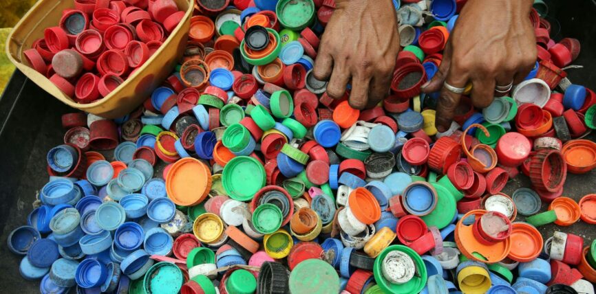 person hands on assorted color plastic lid lot