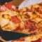 close up photo of person holding pizza