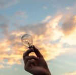 person holding clear light bulb