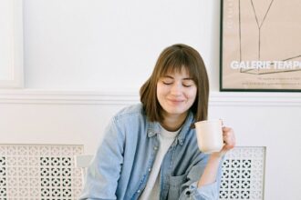 woman drinking coffee and looking at a laptop
