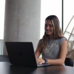 a woman sitting at a table with a laptop