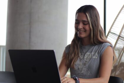 a woman sitting at a table with a laptop