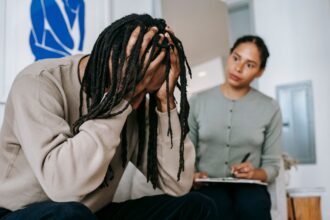 unrecognizable desperate black man with attentive girlfriend at home