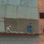 construction site with builders on brick wall