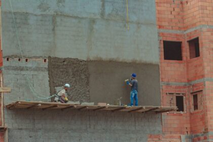 construction site with builders on brick wall