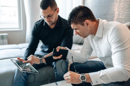 two men pointing at ipad screen
