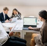 men and women working by table at office