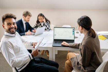 men and women working by table at office